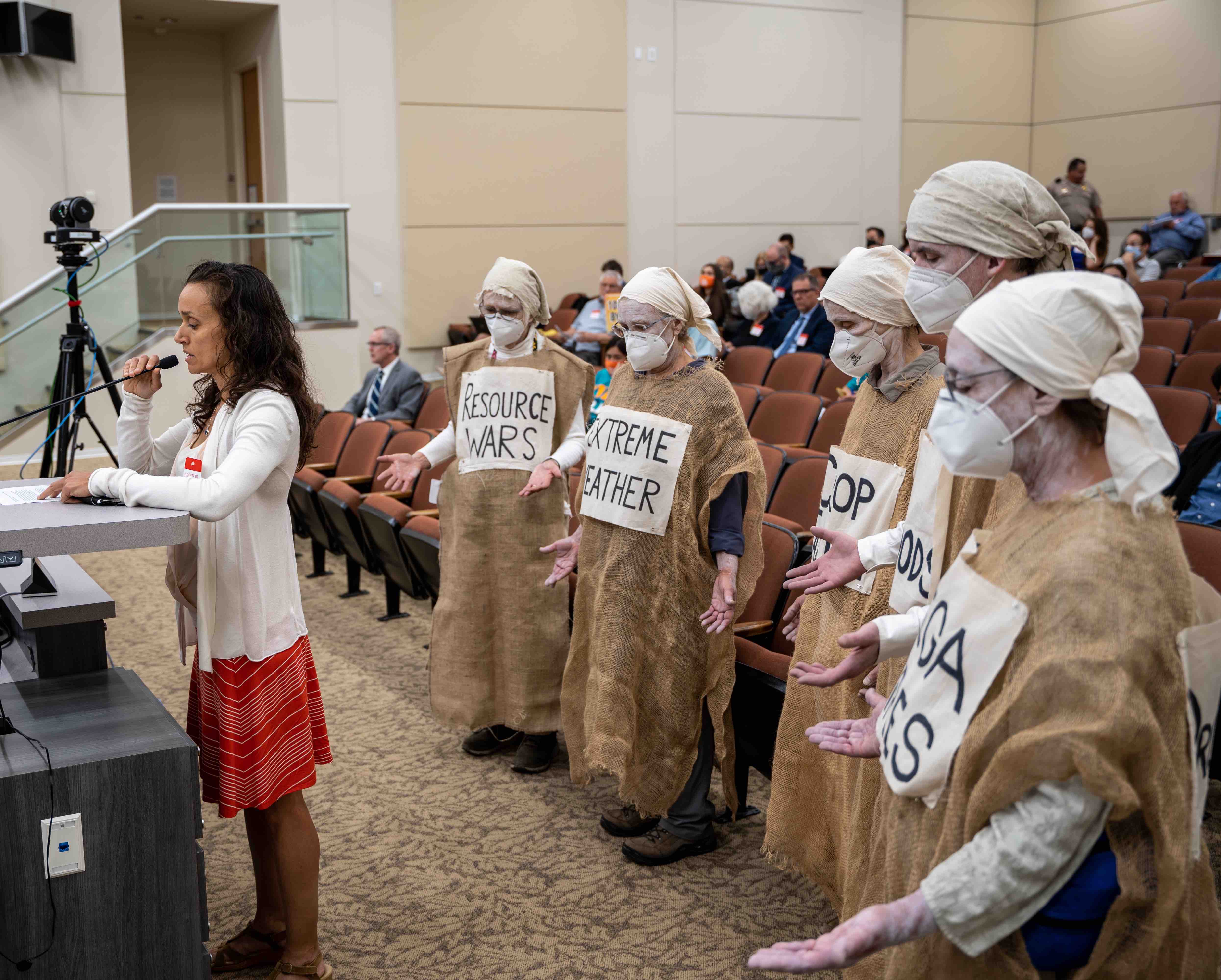 Lamentors 1 Lamentors stand behind speaker at a board meeting